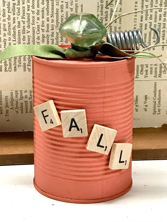 Scrabble letters on an orange pumpkin aluminum can