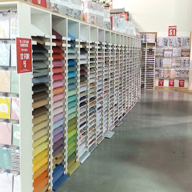 The inside of a scrapbooking paper factory outlet, with rows of paper on display.