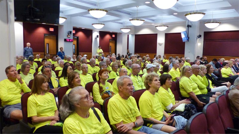 People with yellow shirts sitting at a local meeting in auditorium