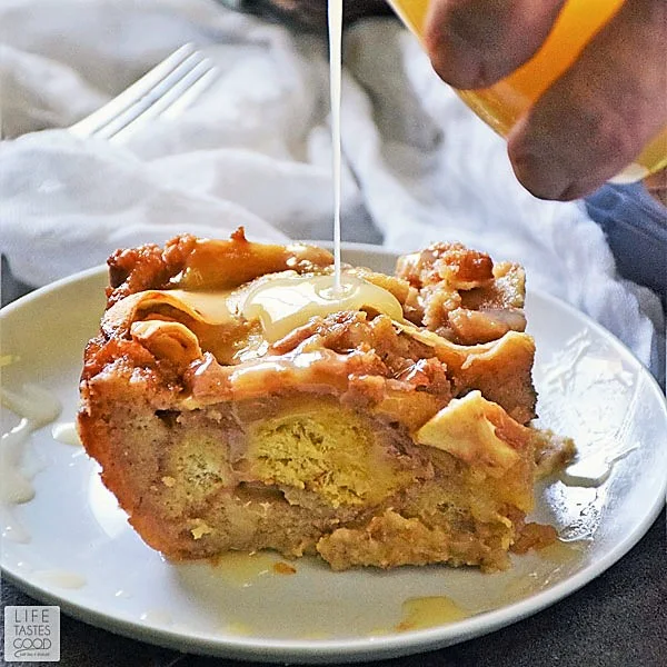A square of Apple Pie Bread Pudding being drizzled with Maple Cream Sauce
