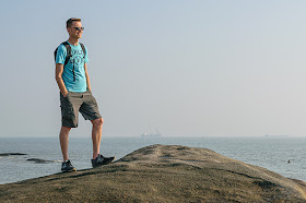 Homme scrutant l'horizon sur la plage de Xiamen