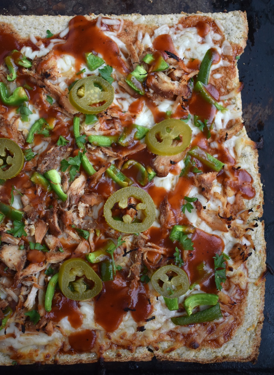  BBQ Chicken Pizza with Cauliflower Crust is nutritious with an 80% cauliflower crust and is topped with shredded chicken, BBQ sauce, mozzarella cheese, bell peppers and jalapenos! www.nutritionistreviews.com #pizza #bbq #cauliflower #healthier #dinner
