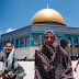 Palestinian children stand in front the Dome of the Rock