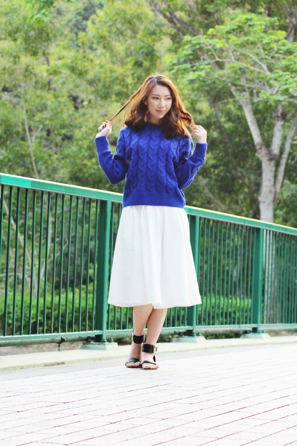 Styling blue sweater with flared white midi skirt and gold buckled sandals