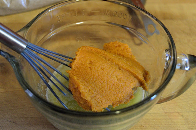 The pumpkin puree being added to the butter. 