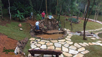 Execução do piso de pedra com junta de grama na execução da cascata de pedra com pedra moledo em sítio em Nazaré Paulista-SP.