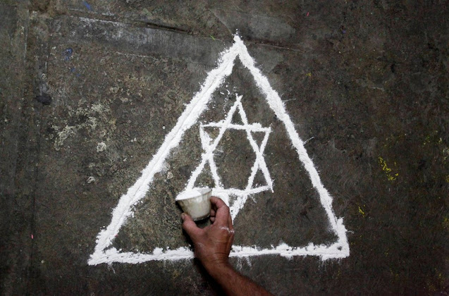 3. Затем он рисует на полу ритуальные знаки.