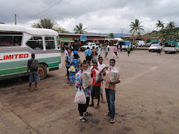Boys selling food to bus passengers