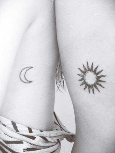 Um preto lua crescente destaque e tribais sol são representados na parte inferior do utente coxas neste tatuagem conjunto.