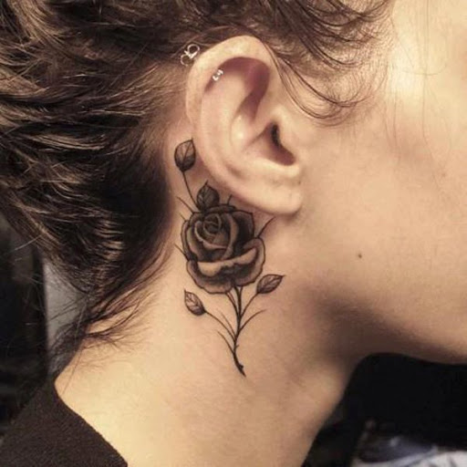 Rosa negra da tatuagem para as mulheres no pescoço e atrás da orelha