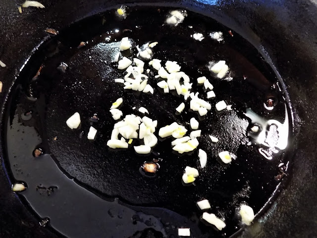 A picture of chopped garlic in a skillet being sauteed. 