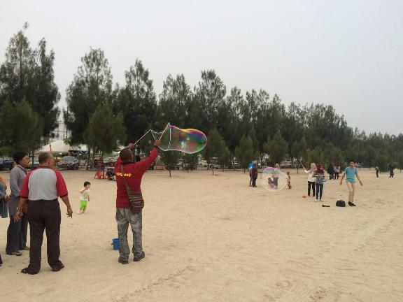 main layang layang dan buih air sabun di pantai puteri