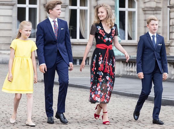 Crown Princess Elisabeth is wearing a embroidered tulle midi dressby Maje. Queen Mathilde wore a red lace dress by Natan