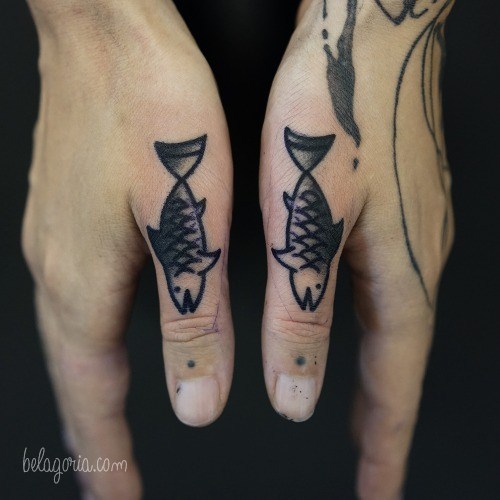 Un tatuaje en los dedos pulgares de dos peces