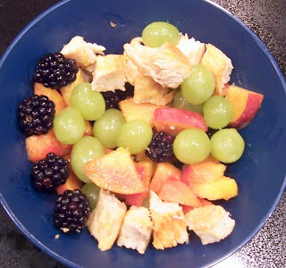 finger food bowl of grilled boneless chicken breast cut into squares with cut up peaches, grapes, and blackberries 