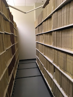photo of shelves with thousands of tan volumes