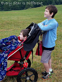 The boys watching hot air balloons set up and take flight.