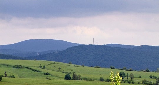 Dział Tylawski (610 m n.p.m.) z masztem przekaźnika telefonii komórkowej. Nieco na lewo za nim wznosi się rozłożysty Kamień nad Jaśliskami, znany też pod nazwą Bieszczad (857 m n.p.m.).