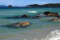 playa de Palmas En Auto a Brasil, la costa del mar con algunas rocas y al fondo la punta de la bahia