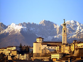 The skyline of Belluno with the Duomo in the foreground  and the Dolomites providing a spectacular backdrop