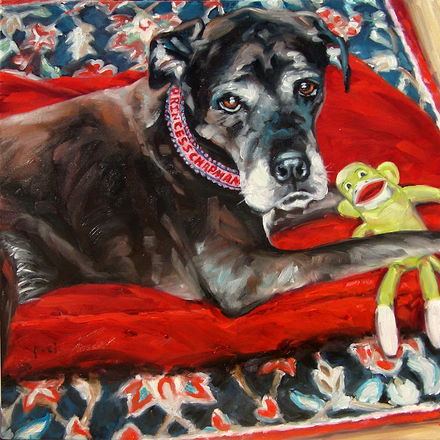 Black Lab and Bulldog mix, lying on her red blanket with monkey toy. Princess is looking up at us.