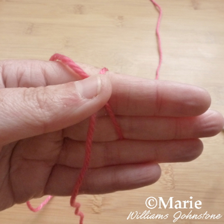 Crossing strands of yarn over hand slip knot method crocheting