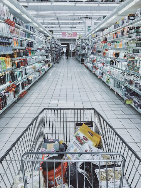 Grocery shopping cart at the end of an aisle inside a grocery store