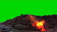 A hot lava rock tumbles down a lava rock formation with green background in sky area.