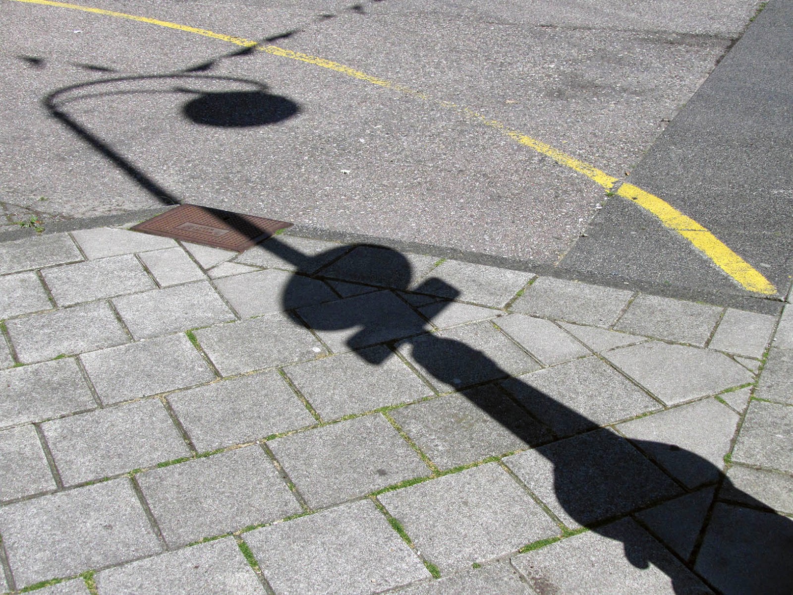 shadow of a lamppost on sidewalk