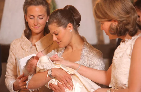Princess Claire of Belgium, Crown Princess Victoria of Sweden holding Princess Eleonore of Belgium and Queen Mathilde of Belgium during the baptism of Princess Eleonore