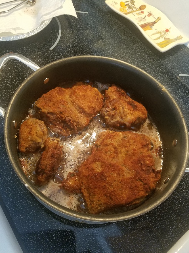 these are fried venison cutlets sitting on top of foil after they are fried. They are crispy golden browned deer meat cutlets that have been marinated and coated with cracker crumbs