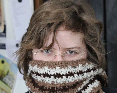woman with face covered by crocheted scarf