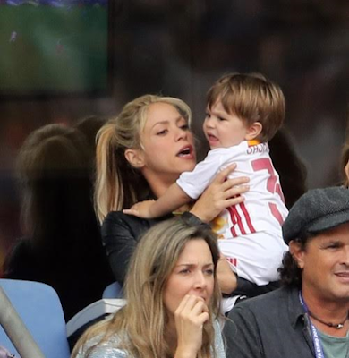 1a2 Shakira and sons cheers on her husband football star Gerard Pique during his game.