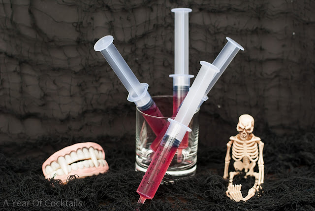 Halloween cocktails shots, blood sample, vanilla vodka, pomegranate juice, plastic syringe