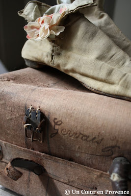 Une ancienne valise de couleur surannée avec le nom du propriétaire écrit à la plume