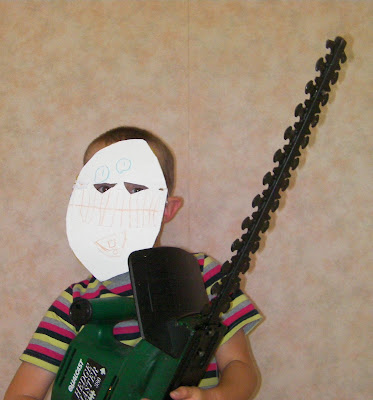 boy with homemade mask and hedge trimmer