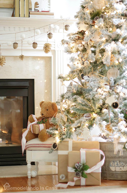 Christmas tree with teddy bear by its side, close to mantel