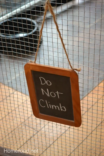 Chalkboard hanging on fence says Do not climb