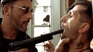 Jean Reno as the hitman Léon, threatens to shoot with pistol,  in Léon: The Professional, Directed by Luc Besson