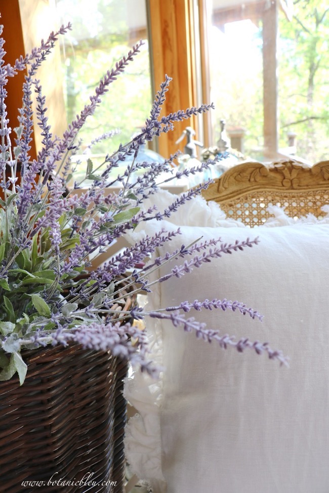 French lavender, wood carved cane-backed chairs, and ruffled linen pillows create a French Country home of your dreams