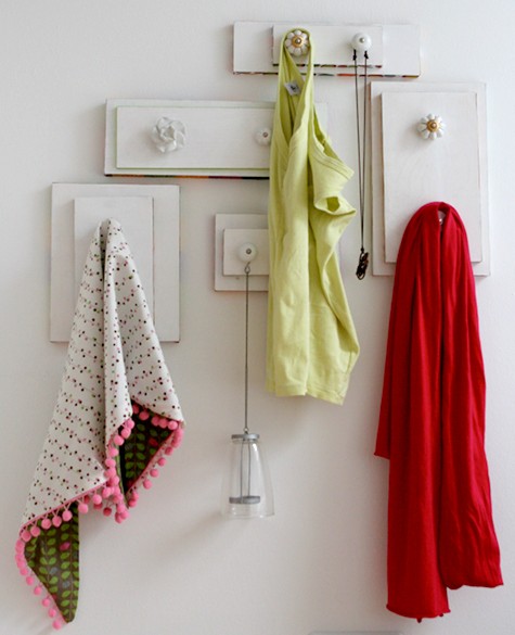 These drawer handles on the wall are a whimsical way to hang clothes and towels. 