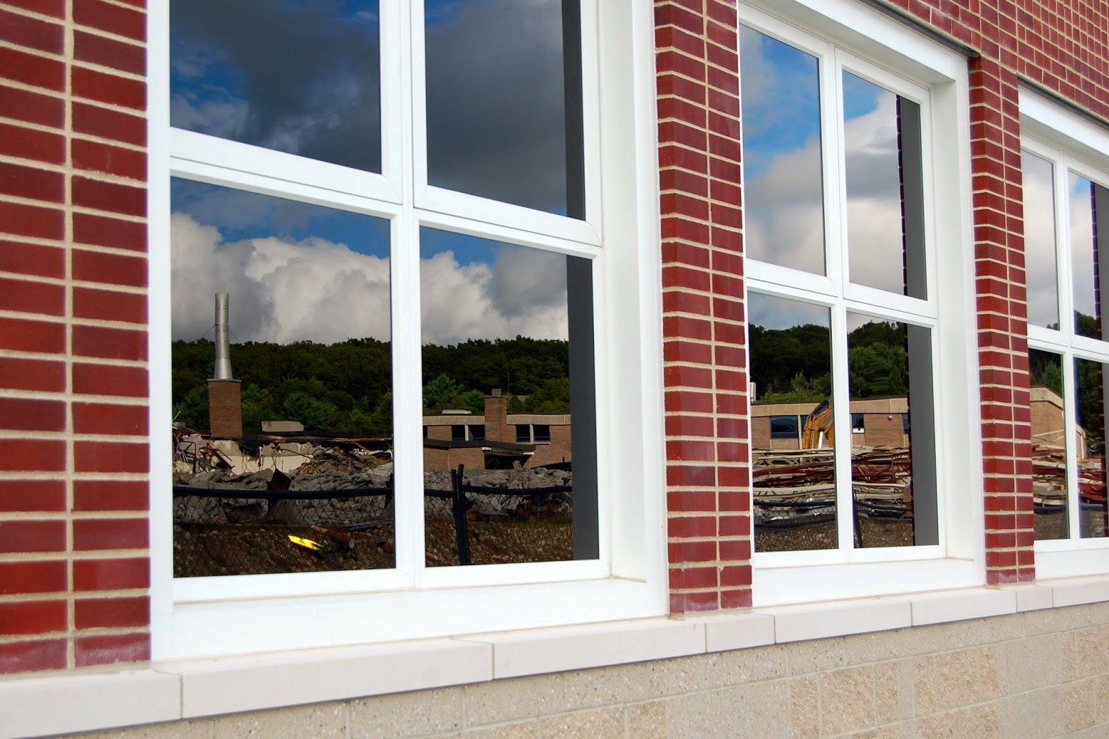 the old building reflected in the windows of the new Franklin High School