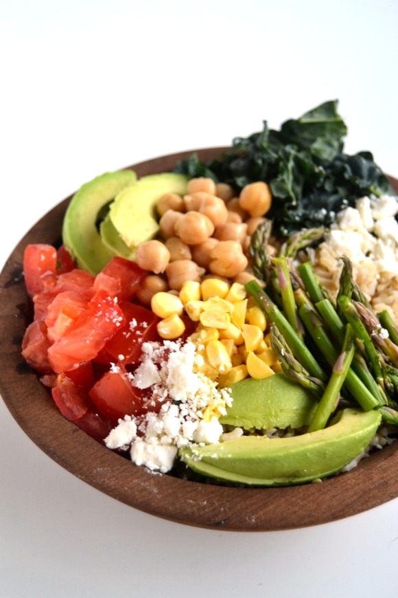 This Veggie Rice Bowl is a hearty and healthy meal that is ready in 20 minutes or less. Packed full of fresh vegetables and topped with a lemon vinaigrette. www.nutritionistreviews.com