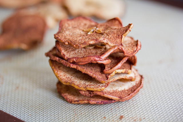 Dried apple chips on top of each other on a baking mat