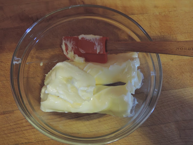 Soften butter in a mixing bowl with a rubber spatula.