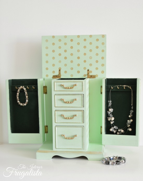 An upcycled thrift store vintage armoire jewelry box painted a pretty mint custom chalk-style paint color with gold accents and fun polka dots inside.