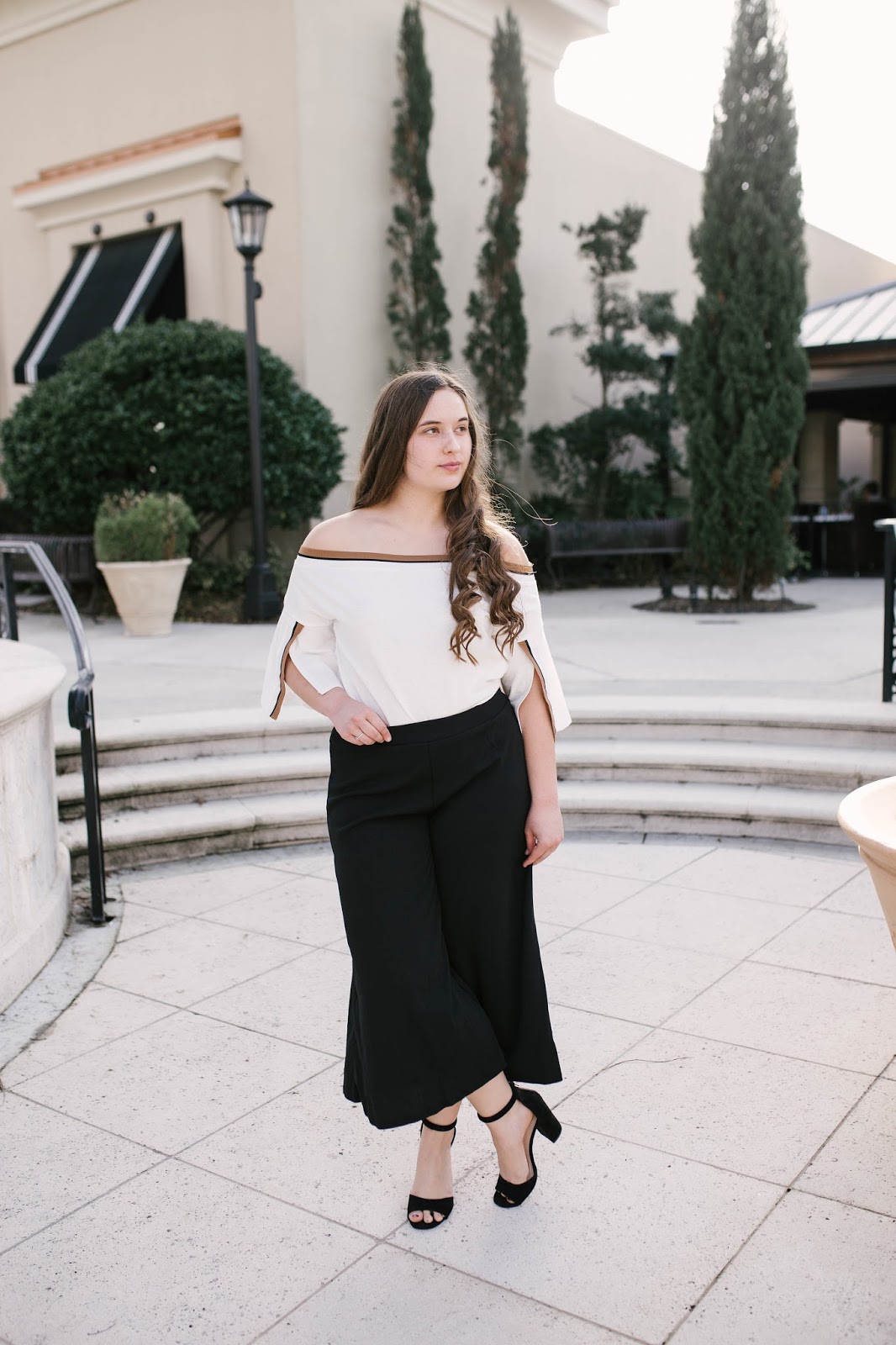 Girl wearing black culotte pants and off the shoulder top