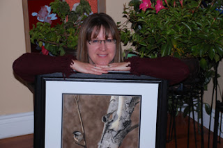 Colette Theriault and her pastel painting of black capped chickadee in a birch tree