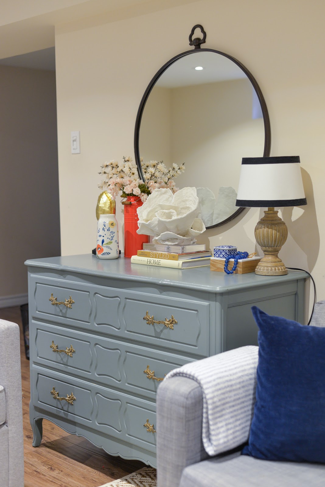 basement update, budget basement makeover, basement living room, coastal vignette, teal dresser, large round mirror over dresser basement update, budget basement makeover, basement living room, coastal vignette, teal dresser, large round mirror over dresser