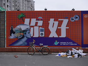 Wanda Plaza "你好" sign on a wall bordering a construction site in Mudanjiang, China